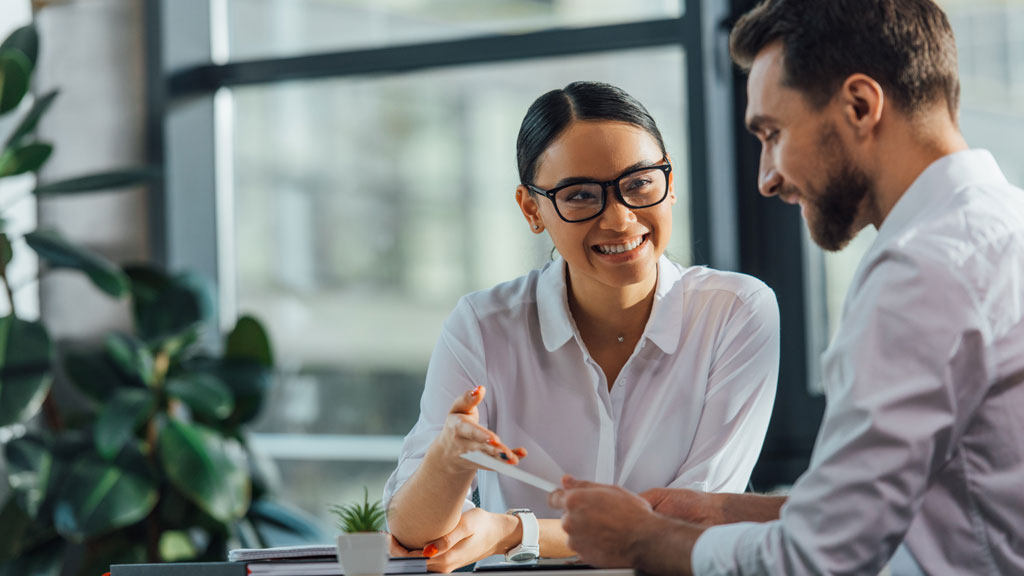 Deux professionnels français discutant debout dans bureau moderne, conversation décontractée sur création d'entreprise