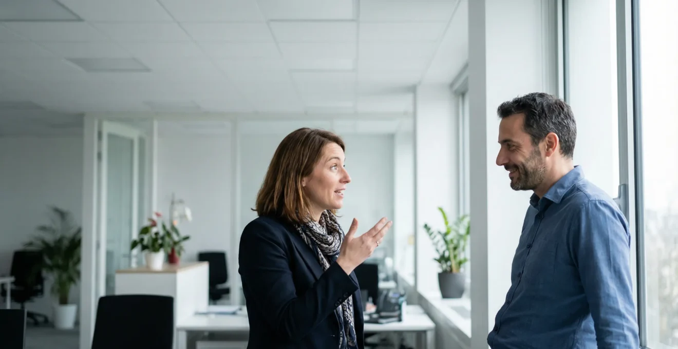 Deux professionnels français discutant debout dans bureau moderne, conversation décontractée sur création d'entreprise